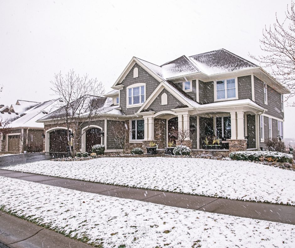 A large, cozy, home, with clear pathways in a gentle snow.